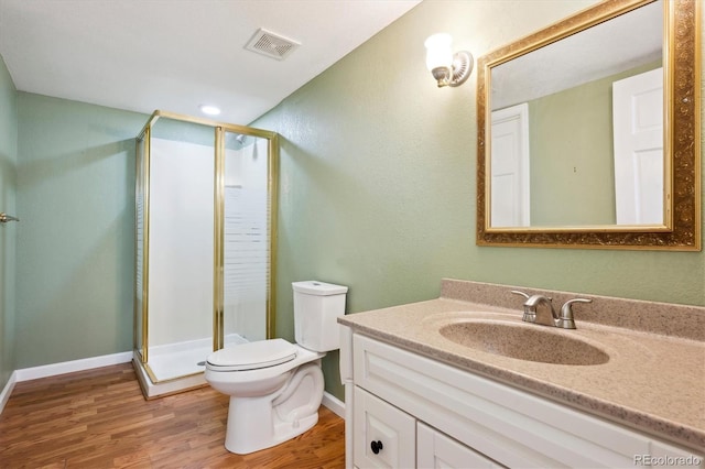 bathroom with hardwood / wood-style floors, toilet, walk in shower, and vanity