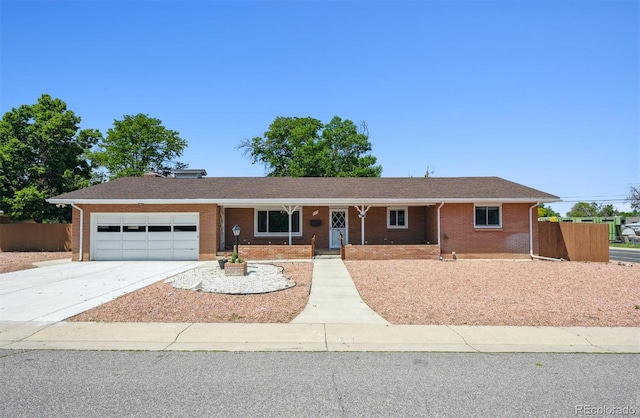 209 S 13th Ave, Brighton, CO 80601 - ranch-style house featuring an attached garage, brick siding, concrete driveway, and a porch