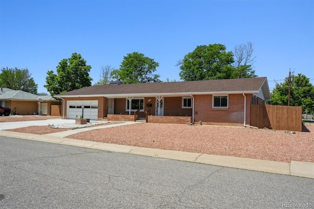 209 S 13th Ave, Brighton, CO 80601 - single story home with concrete driveway, an attached garage, brick siding, and covered porch