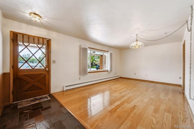 209 S 13th Ave, Brighton, CO 80601 - entryway featuring a baseboard radiator, healthy amount of natural light, a chandelier, and wood finished floors