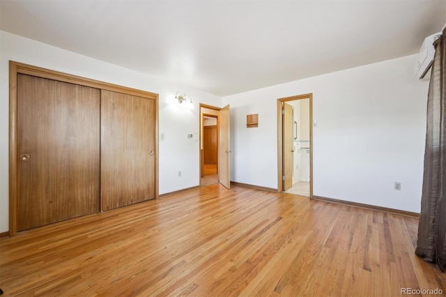 209 S 13th Ave, Brighton, CO 80601 - unfurnished bedroom featuring a closet, light wood-type flooring, an AC wall unit, and baseboards