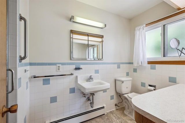 209 S 13th Ave, Brighton, CO 80601 - bathroom featuring baseboard heating, toilet, wainscoting, a sink, and tile walls