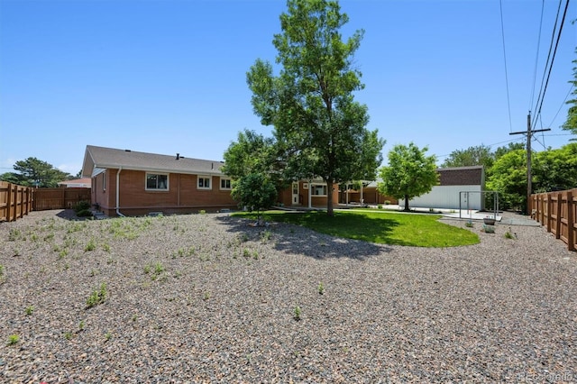 209 S 13th Ave, Brighton, CO 80601 - back of property featuring a fenced backyard and an outdoor structure