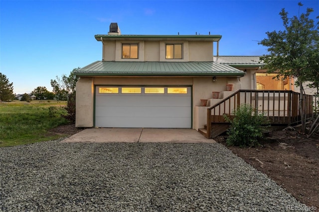 4627 Cathy Ln, Erie, CO 80516 - view of front facade featuring stucco siding, a metal roof, an attached garage, and gravel driveway