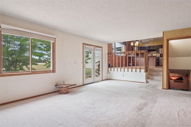 4627 Cathy Ln, Erie, CO 80516 - unfurnished living room featuring carpet floors, a textured ceiling, and stairway