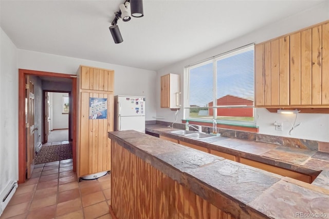 4627 Cathy Ln, Erie, CO 80516 - kitchen with freestanding refrigerator, a baseboard heating unit, tile counters, light brown cabinetry, and light tile patterned flooring