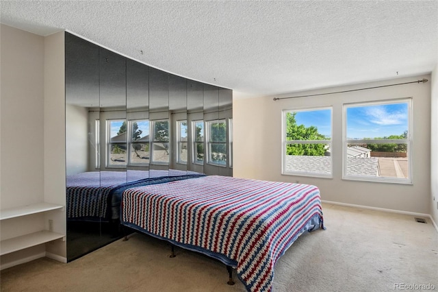 carpeted bedroom featuring a textured ceiling and baseboards