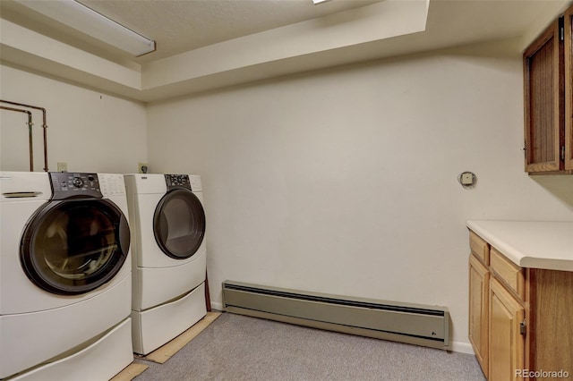 clothes washing area featuring cabinets, washing machine and dryer, light carpet, and a baseboard radiator