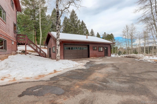 view of snow covered exterior with a garage