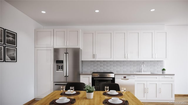 kitchen featuring a sink, backsplash, baseboards, and appliances with stainless steel finishes