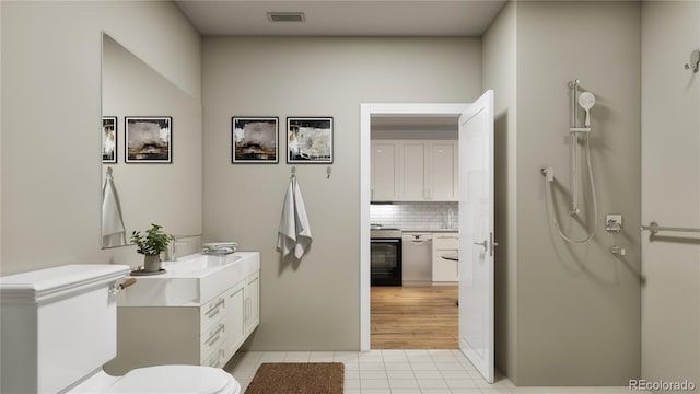 bathroom with toilet, tile patterned floors, visible vents, decorative backsplash, and vanity