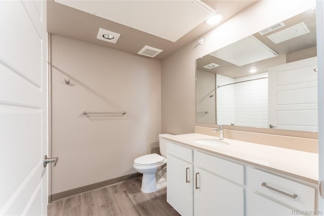 bathroom featuring vanity, toilet, wood-type flooring, and walk in shower