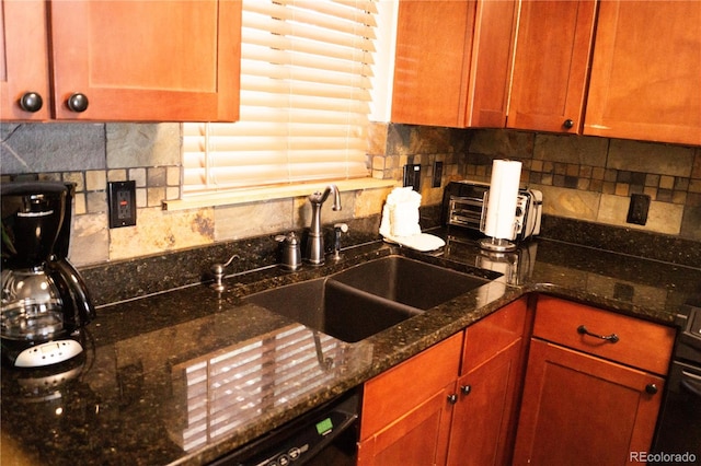 kitchen featuring backsplash, dark stone countertops, and sink