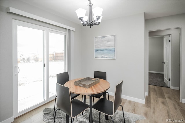 dining room with a notable chandelier, light wood-type flooring, and a wealth of natural light