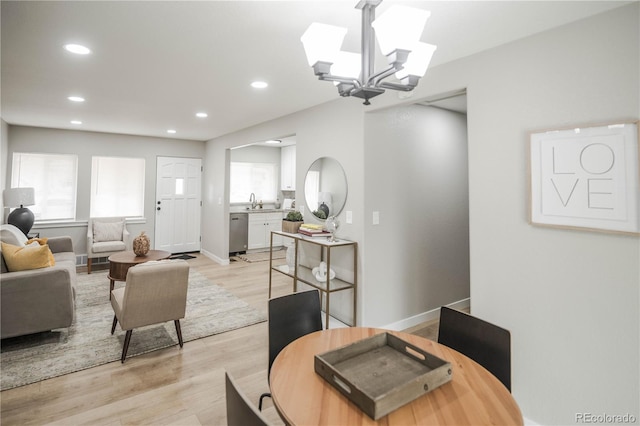 living room with light hardwood / wood-style flooring, a notable chandelier, and a wealth of natural light