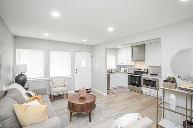 living room with sink and light wood-type flooring