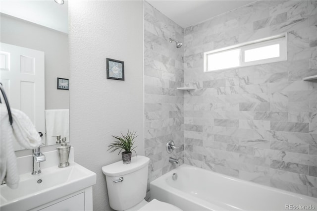 full bathroom featuring vanity, tiled shower / bath combo, and toilet