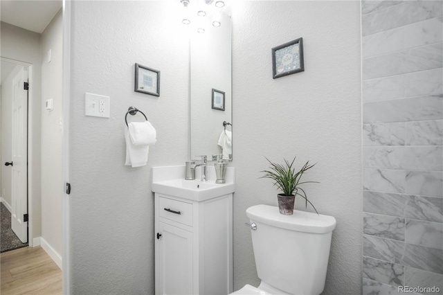 bathroom featuring vanity, hardwood / wood-style floors, and toilet