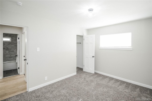 unfurnished bedroom with light colored carpet and a closet