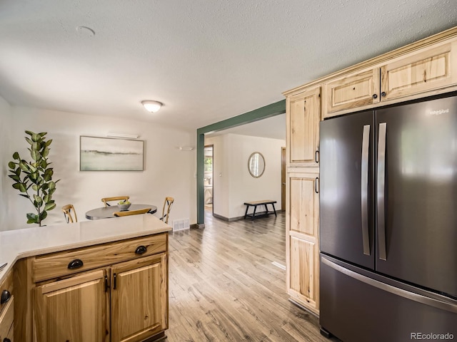 2617 Cedar Dr, Loveland, CO 80538 - kitchen with freestanding refrigerator, light countertops, light wood-style flooring, a textured ceiling, and baseboards