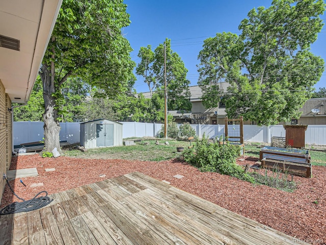 2617 Cedar Dr, Loveland, CO 80538 - wooden terrace featuring a storage unit, an outbuilding, a fenced backyard, and a garden