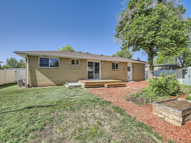 2617 Cedar Dr, Loveland, CO 80538 - rear view of house featuring a vegetable garden, brick siding, central AC unit, a wooden deck, and a storage unit
