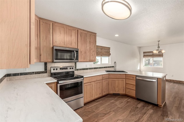 1155 Black Hawk Rd, Eaton, CO 80615 - kitchen with stainless steel appliances, a peninsula, light brown cabinets, dark wood-style floors, and light countertops