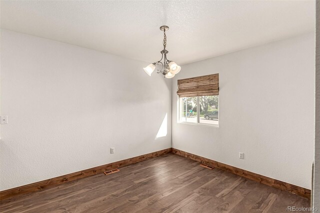 1155 Black Hawk Rd, Eaton, CO 80615 - spare room featuring dark wood-style floors and a chandelier