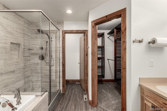 1155 Black Hawk Rd, Eaton, CO 80615 - bathroom with a stall shower, vanity, a bath, and wood finished floors