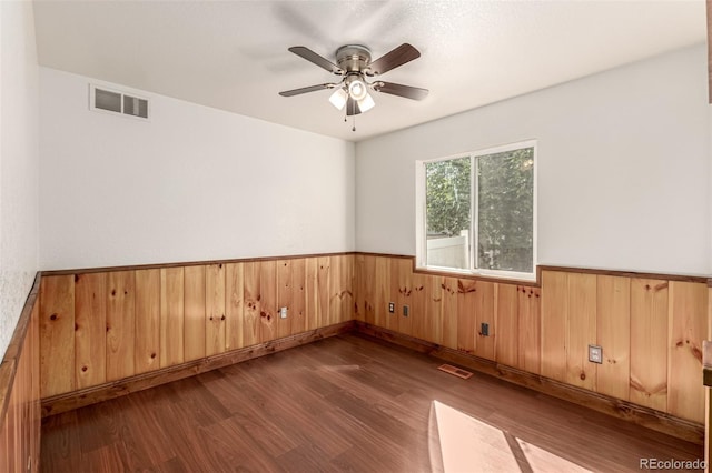 1155 Black Hawk Rd, Eaton, CO 80615 - spare room with wood finished floors, a wainscoted wall, a ceiling fan, and wood walls
