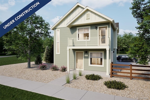 view of front facade with a balcony, board and batten siding, and fence