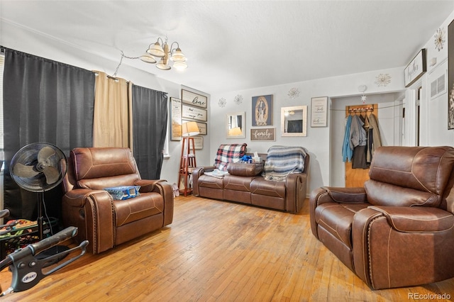 living room featuring a notable chandelier and light hardwood / wood-style floors