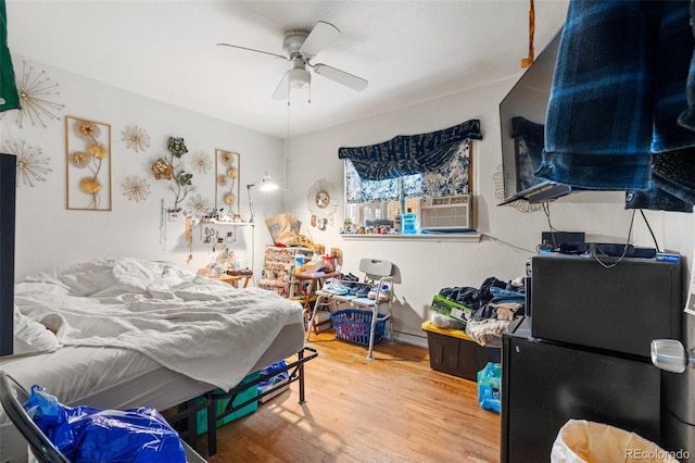 bedroom with ceiling fan, cooling unit, a baseboard radiator, and hardwood / wood-style flooring