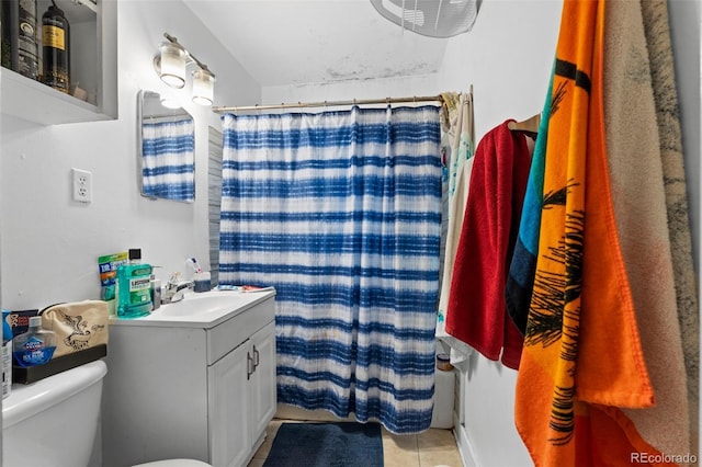 bathroom with toilet, vanity, tile patterned flooring, and walk in shower