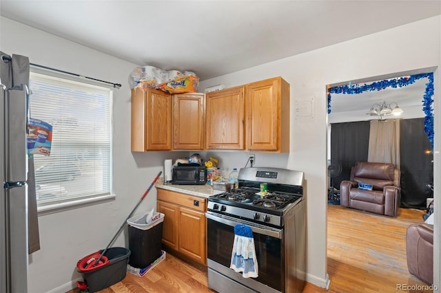 kitchen featuring light wood-type flooring and stainless steel gas range oven