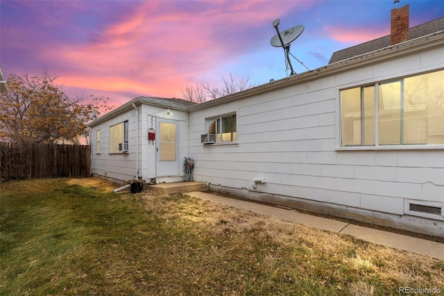 view of front of property with cooling unit and a yard