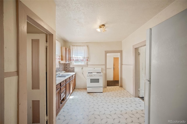 125 S Limit St, Colorado Springs, CO 80905 - kitchen with white appliances, light countertops, a textured ceiling, light floors, and brown cabinetry