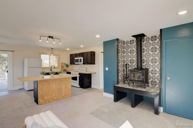 31252 County Road 384a, Buena Vista, CO 81211 - kitchen featuring white appliances, a center island, plenty of natural light, a wood stove, and recessed lighting