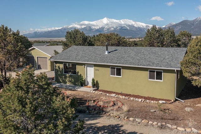 31252 County Road 384a, Buena Vista, CO 81211 - view of front of property with a mountain view, stucco siding, a garage, and a shingled roof