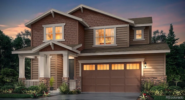 craftsman-style house with concrete driveway, a garage, and stone siding