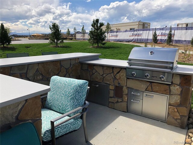 view of patio / terrace with a grill, exterior kitchen, and fence