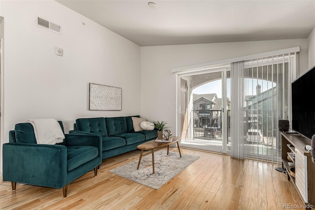 living room featuring vaulted ceiling and wood-type flooring