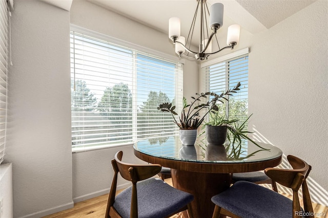 dining area with hardwood / wood-style floors and a chandelier