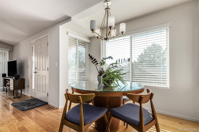 dining room featuring hardwood / wood-style flooring, a chandelier, and a textured ceiling