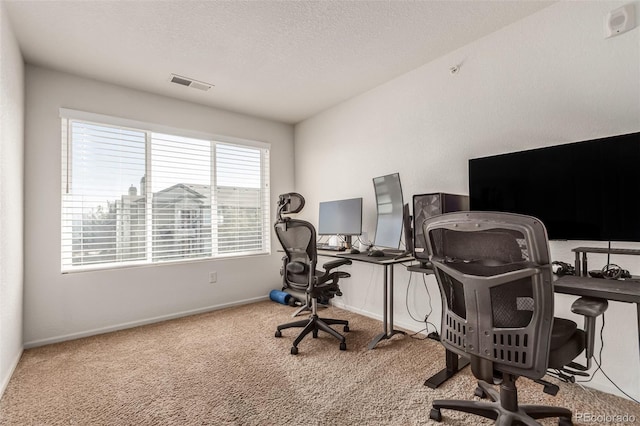 carpeted office space featuring a textured ceiling