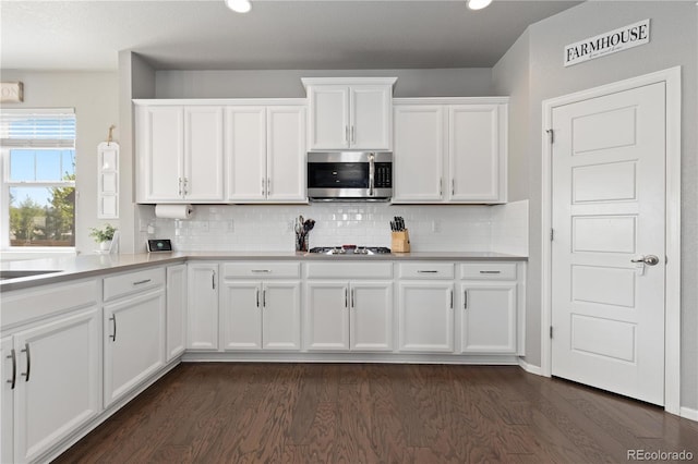 1315 Sidewinder Cir, Castle Rock, CO 80108 - kitchen with appliances with stainless steel finishes, dark wood finished floors, white cabinets, tasteful backsplash, and light countertops