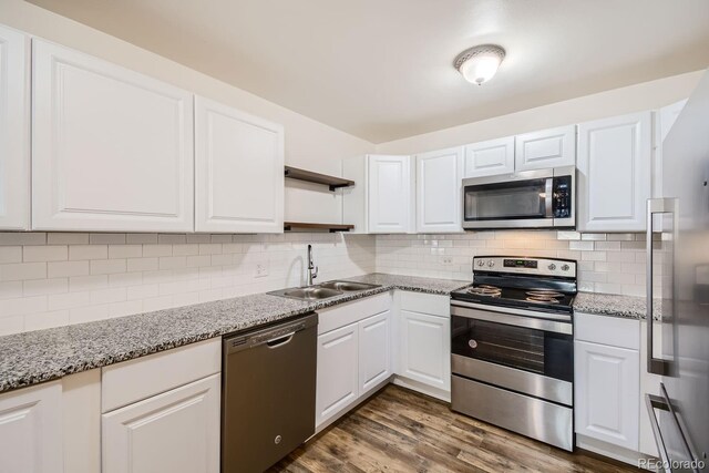 kitchen featuring appliances with stainless steel finishes, sink, white cabinets, and dark hardwood / wood-style floors