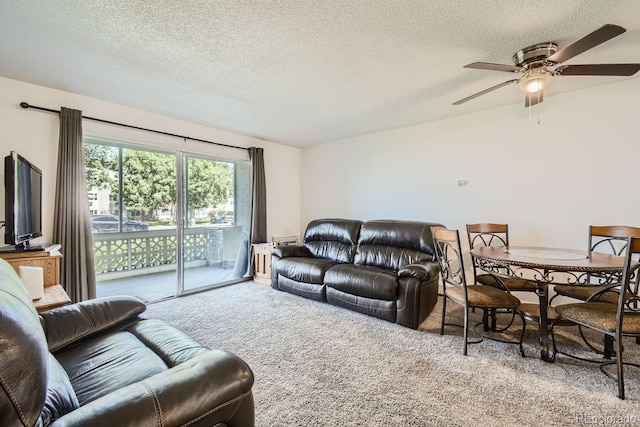 living room with ceiling fan, light carpet, and a textured ceiling