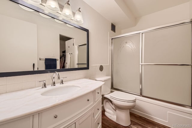 full bathroom with toilet, shower / bath combination with glass door, vanity, tasteful backsplash, and wood-type flooring