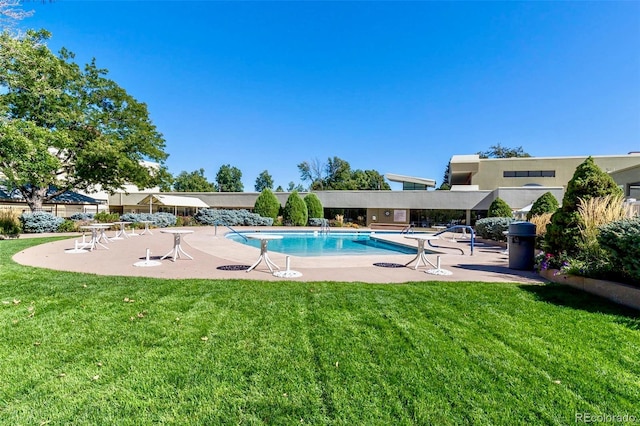 view of pool featuring a yard and a patio